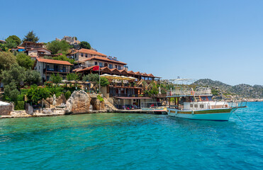 Village on the seaside. Moored ship, yacht. Azure, clear water.