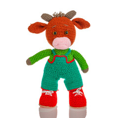 Knitted woven sewn wool toy in the form of an animal bull, isolated on a white background, a soft toy for children