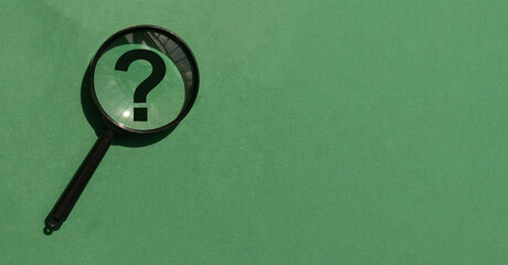 Magnifying lens over green background with copyspace. Banner with magnifier, question mark and...