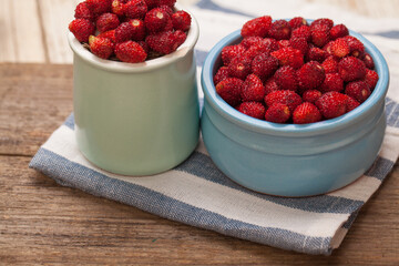 Red organic strawberries in blue and green bowls