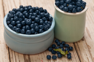 Organic blueberries in blue bowls on vintage wooden table