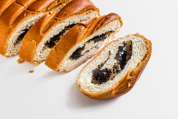 Wheat flour roll with poppy seed filling on a white background