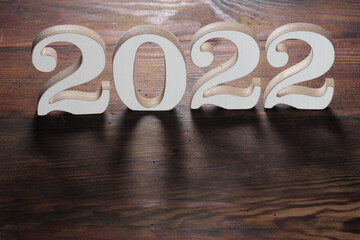Happy New Year. Symbol from number 2022 on wooden background