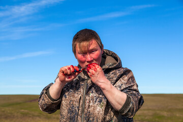The extreme north, Yamal, the preparation of deer meat, the male reindeer breeder eats fresh meat,...