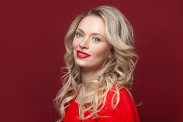 Happy fashion model woman smiling, beautiful female face close up on red background