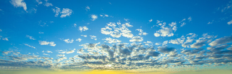 Blue sky clouds background. Beautiful sunshine landscape with clouds and orange sun on sky