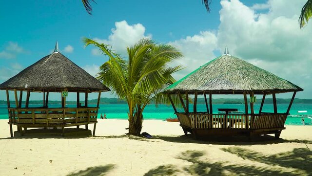 Tropical beach with bungalow under palm trees of Daco, Philippines. Summer and travel vacation concept