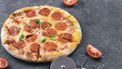 pepperoni pizza with tomato slices on concrete surface