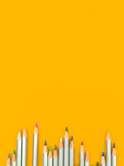 School vertical background with color pencils. Yellow and orange table desktop with school stationery. Top view, copy space and flat lay photo