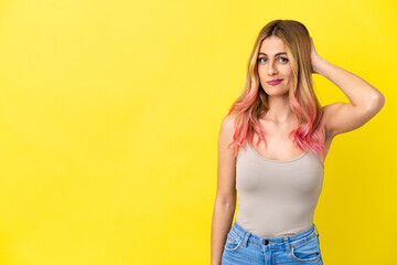 Young woman over isolated yellow background having doubts