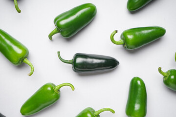 Group of jalapeno peppers on a white background, top view. Close-up. Green chili pepper.