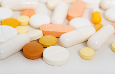 Lots of scattered pills, capsules on white background with copy space flat lay. Medicine and pharmacy concept. Multicolored