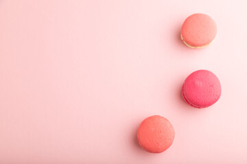 Magenta and pink macaroons on pink pastel background.  top view, copy space.