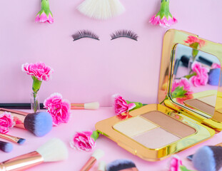 Obraz na płótnie Canvas face with false eyelashes and flowers, premium makeup brushes on a colored pink background, creative cosmetics flat lay