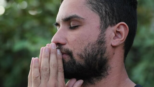 Spiritual hispanic man feeling freedom, taking a deep breath outside