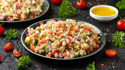 Quinoa white bean salad with cherry tomatoes, cucumber, red onion and herbs. Healthy vegan food