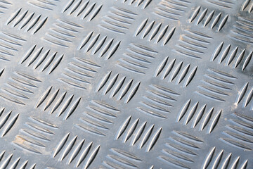 Detail of a silver stainless steel floor. There is a corrugation that resembles a braided pattern....