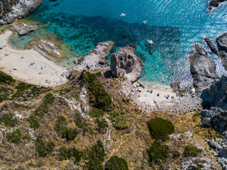 Aerial view of Capo Vaticano, Calabria, Italy. Lighthouse and promontory. Rocks overlooking the sea. Praia I Focu beach and A Ficara beach. Boats and bathers and crystal clear sea. Costa degli Dei