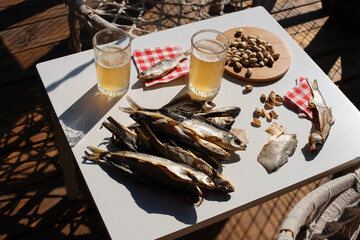 Cold beer and dried salted fish. Top view. Summer, hard shadows, relax, holyday