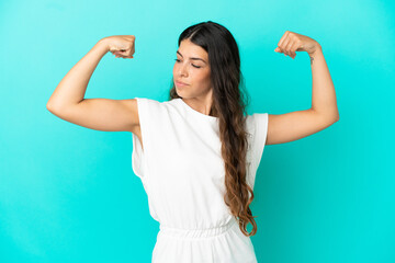 Fototapeta premium Young caucasian woman isolated on blue background doing strong gesture