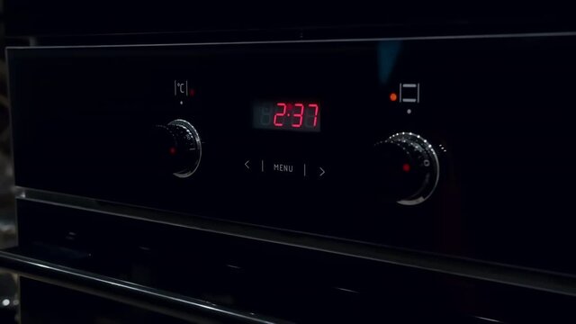man turns on the oven for baking, cooking dinner at home, mooving camera, cinematic shot