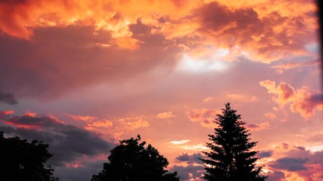 An HD footage of the bright red and oran clouds in the sky during an evening
