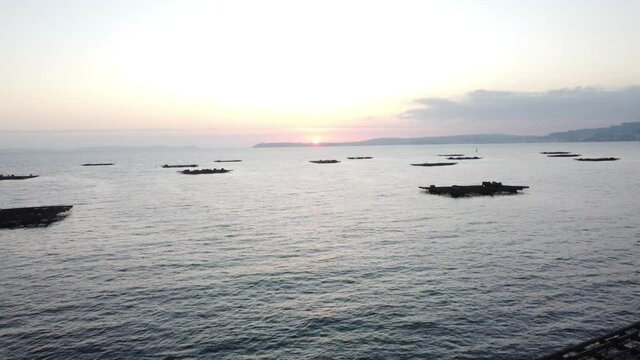 Criadero de mejillones. Bateas en Galicia al atardecer. Marisco. Marineros.