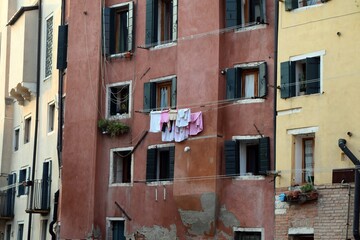 Fototapeta na wymiar Laundry hanging on a string between two windows in a building in Venice.