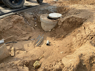 Concrete manhole in a pit at a construction site. Industrial construction of sewerage engineering networks