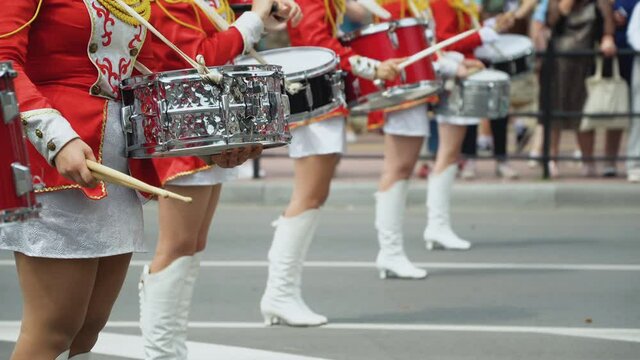 Young girls drummer in red vintage uniform at the parade. Street performance. Parade of majorettes