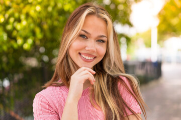 Young pretty blonde girl at outdoors With happy expression