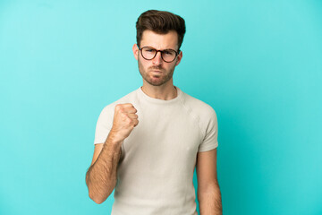 Young caucasian handsome man isolated on blue background with unhappy expression