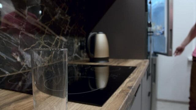 man takes milk from the refrigerator and pours it into a glass in the modern kitchen, cinematic shot