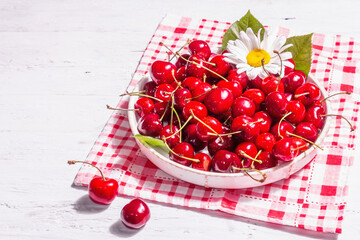 Fresh ripe sweet cherries in a bowl with droplets of water