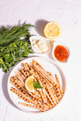 Grilled scorzonera with sauces set with modern hard light, dark shadow