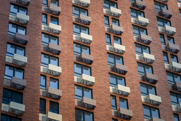 The facade of a new high-rise building with windows and compartments for external blocks of split systems. Fastening outdoor units of air conditioners