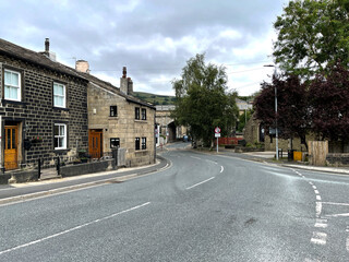 Fototapeta na wymiar Junction of, Scout Road, with houses, trees, and a cloudy sky in, Mytholmroyd, Hebden Bridge, UK