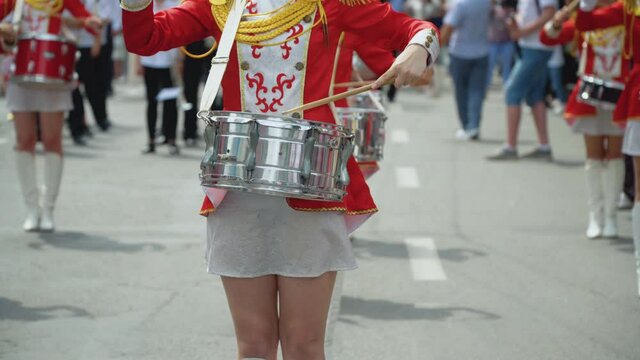 Young girls drummer in red vintage uniform at the parade. Street performance. Parade of majorettes