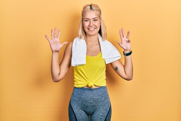 Beautiful blonde sports woman wearing workout outfit showing and pointing up with fingers number...