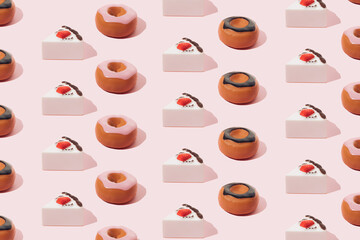 Plastic sweets. Donuts with chocolate and pink glaze and strawberry cake on a pink background.