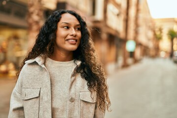 Fototapeta premium Young latin woman smiling happy standing at the city.