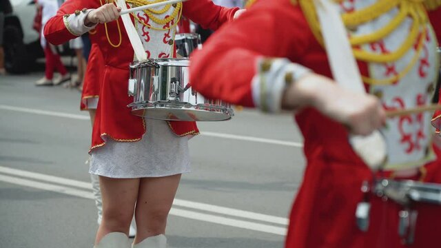 Young girls drummer in red vintage uniform at the parade. Street performance. Parade of majorettes