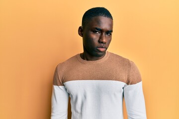 Young african american man wearing casual clothes skeptic and nervous, frowning upset because of...