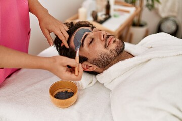 Man reciving facial treatment at beauty center.