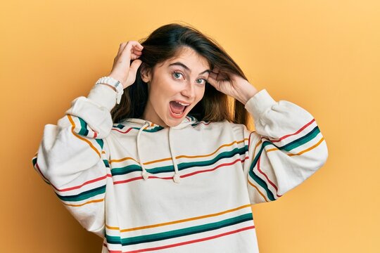 Young caucasian woman wearing casual clothes smiling pulling ears with fingers, funny gesture. audition problem