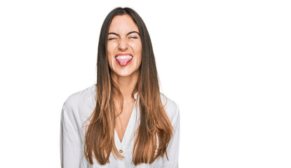 Young beautiful woman wearing casual clothes sticking tongue out happy with funny expression. emotion concept. © Krakenimages.com