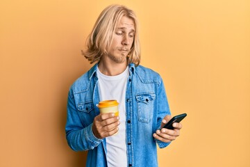 Caucasian young man with long hair using smartphone and drinking a cup of coffee skeptic and nervous, frowning upset because of problem. negative person. - Powered by Adobe