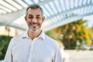 Middle age grey-haired man smiling happy standing at the city.