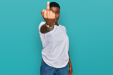 Young african american woman wearing casual white t shirt showing middle finger, impolite and rude...