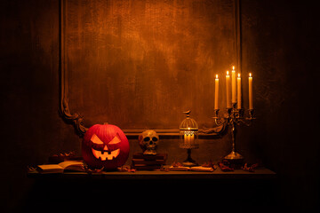 Scary laughing pumpkin and old skull on ancient gothic fireplace. Halloween, witchcraft and magic.